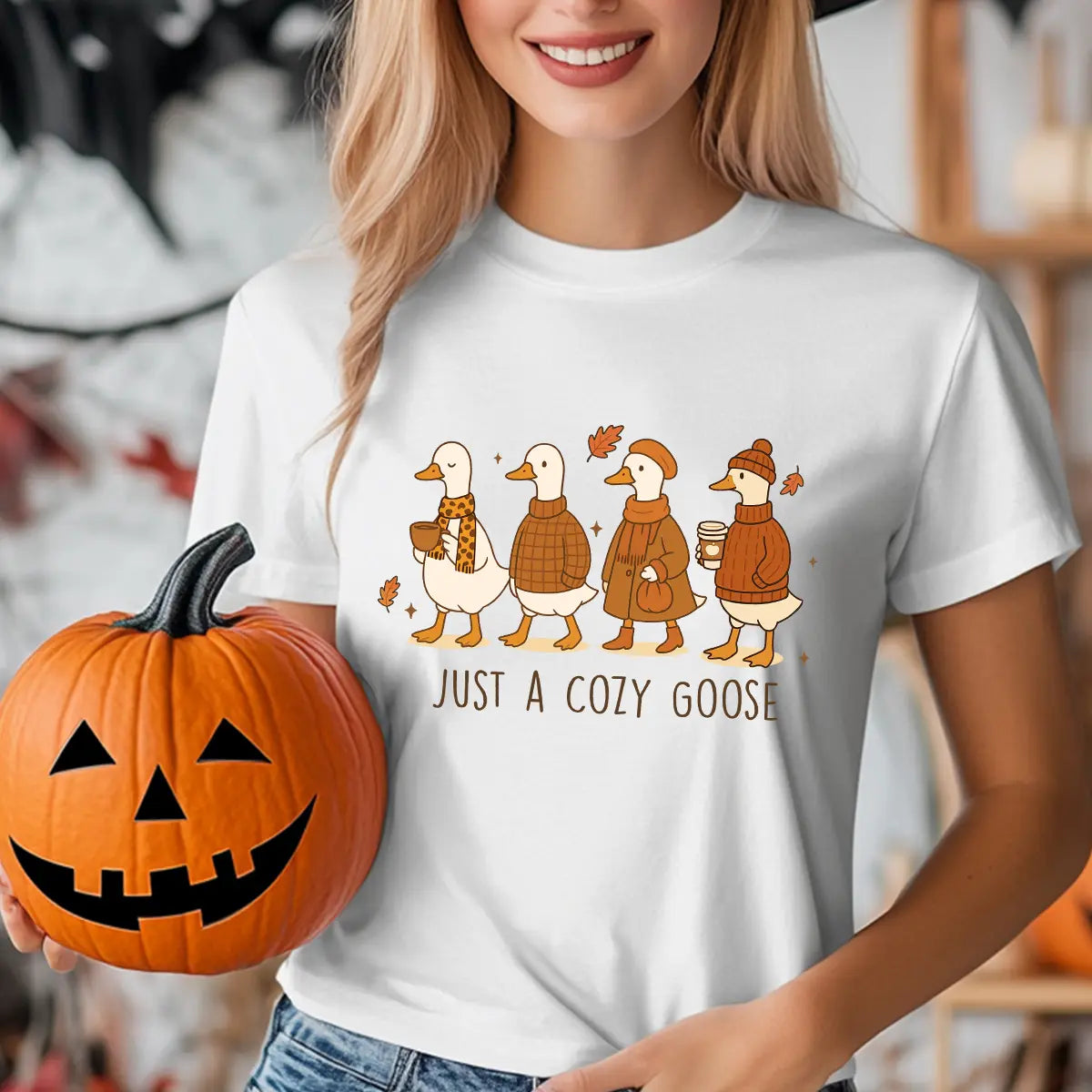 White T-shirt with “Just a Cozy Goose” DTF transfer design featuring four autumn-dressed geese with scarves, hats, and warm drinks.