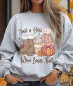 Gray sweatshirt with “Just a Girl Who Loves Fall” DTF transfer design featuring cozy fall boots, coffee, beanie, pumpkin with bow, and autumn leaves.
