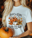 White T-shirt with “Just a Girl Who Loves Fall” DTF transfer design featuring pumpkins with a bow, sunflowers, fall leaves, and coffee.