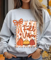 Gray sweatshirt with “Fall Vibes” DTF transfer design featuring pumpkins, autumn pie, orange bow, and falling leaves in a decorative border.