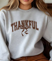 Gray sweatshirt with brown collegiate “THANKFUL” text and rustic bow DTF transfer design, perfect for Thanksgiving and fall-themed apparel.
