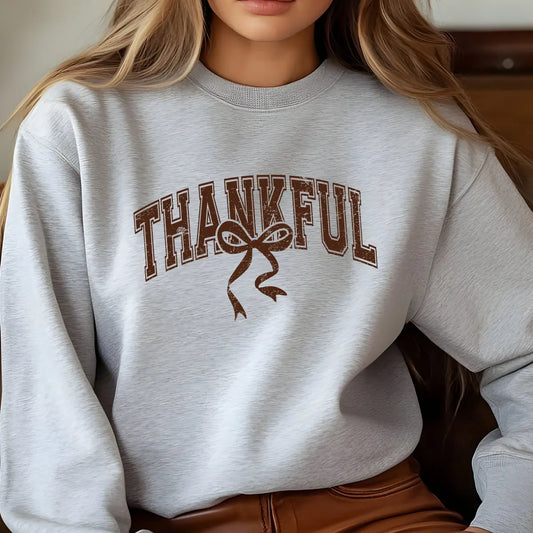 Gray sweatshirt with brown collegiate “THANKFUL” text and rustic bow DTF transfer design, perfect for Thanksgiving and fall-themed apparel.