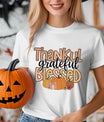 White t-shirt with “Thankful Grateful Blessed” marquee and script DTF transfer design featuring pumpkins and flowers, perfect for Thanksgiving and fall fashion.