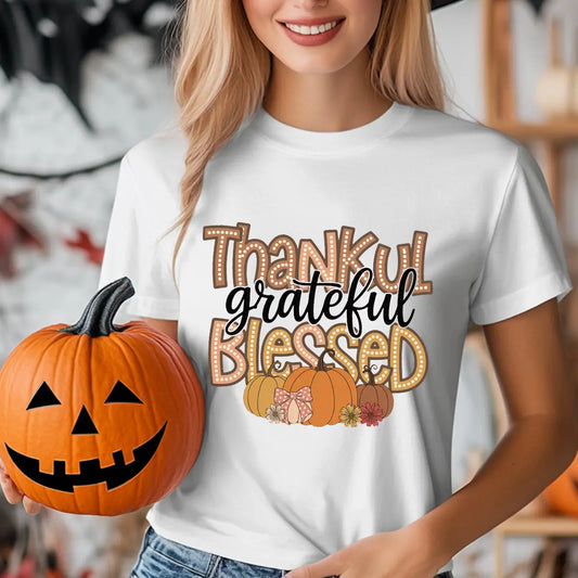 White t-shirt with “Thankful Grateful Blessed” marquee and script DTF transfer design featuring pumpkins and flowers, perfect for Thanksgiving and fall fashion.