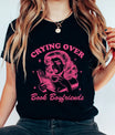 Black t-shirt with pink retro design “Crying Over Book Boyfriends” DTF transfer featuring a dramatic woman reading.