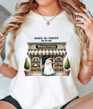 Natural t-shirt with “When in Doubt Go to the Bookstore” DTF transfer featuring a cute ghost in front of a cozy bookstore for spooky reader style.