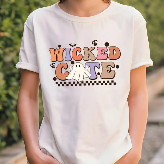 White t-shirt with Halloween design featuring retro bubble letters “Wicked Cute,” peace-sign ghost, checkerboard base, bats, and skulls.