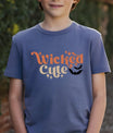 Navy t-shirt with retro orange and cream “Wicked Cute” lettering, sparkles, and a black bat graphic DTF transfer design, perfect for kids’ Halloween apparel.
