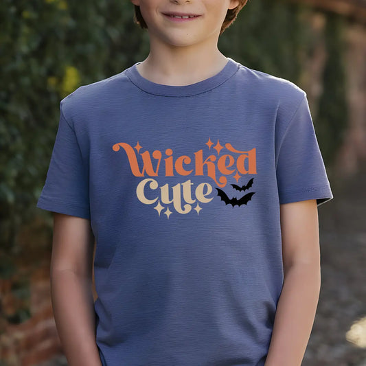 Navy t-shirt with retro orange and cream “Wicked Cute” lettering, sparkles, and a black bat graphic DTF transfer design, perfect for kids’ Halloween apparel.