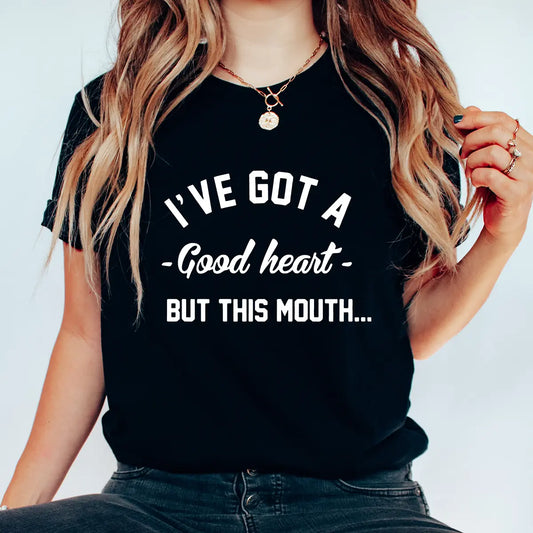 Black t-shirt with bold white text “I’ve Got a Good Heart But This Mouth” DTF transfer design, funny and sassy quote shirt.