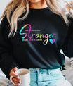 Black sweatshirt with rainbow gradient text “Stronger Than the Storm” and heart accent DTF transfer design, inspirational and motivational apparel.