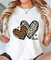 Natural t-shirt with two overlapping leopard print hearts and “love” script DTF transfer design, trendy and stylish heart-themed apparel.