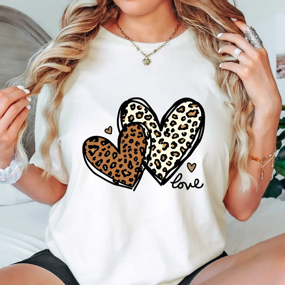 Natural t-shirt with two overlapping leopard print hearts and “love” script DTF transfer design, trendy and stylish heart-themed apparel.
