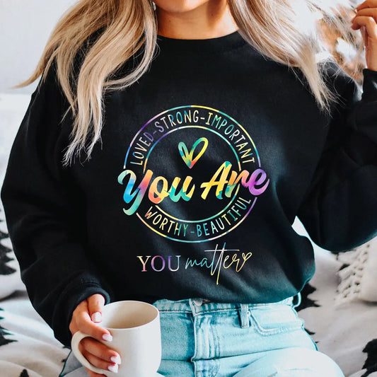 Black sweatshirt with rainbow gradient “You Are Loved Strong Important Worthy Beautiful – You Matter” DTF transfer design, featuring a heart accent, perfect for inspirational apparel.