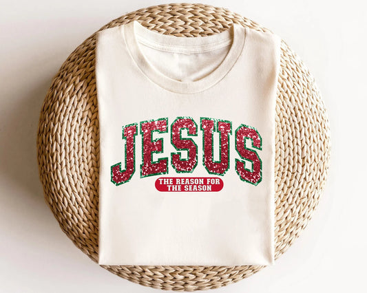 "Jesus - The Reason for the Season" DTF transfer in sparkling red and green lettering on a white sweatshirt.