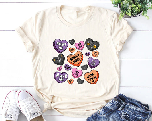 Halloween-themed candy hearts DTF transfer on a cream t-shirt with messages like 'Haunt Me' and 'Spooky Vibes