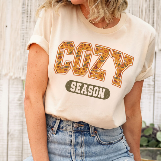 ream t-shirt with 'Cozy Season' iron-on DTF heat transfer, showcasing bold letters with autumn leaf patterns