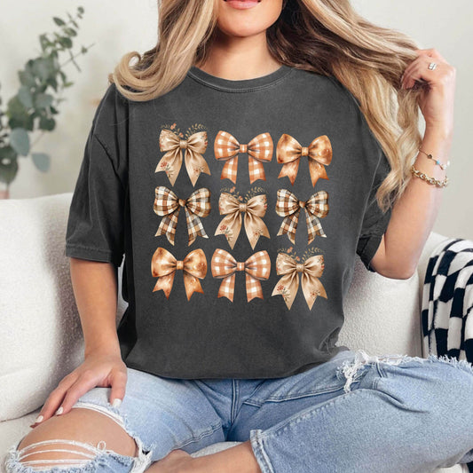 Woman wearing a dark gray t-shirt with 'Elegant Autumn Bows' DTF transfer featuring a variety of stylish bows