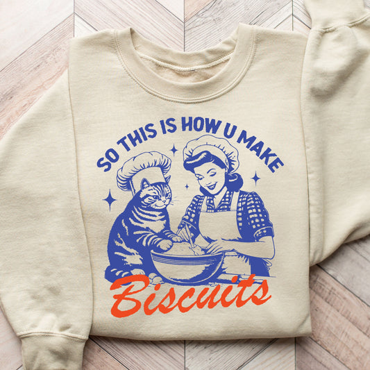 Vintage-style 'So This Is How U Make Biscuits' graphic on a cream-colored sweatshirt