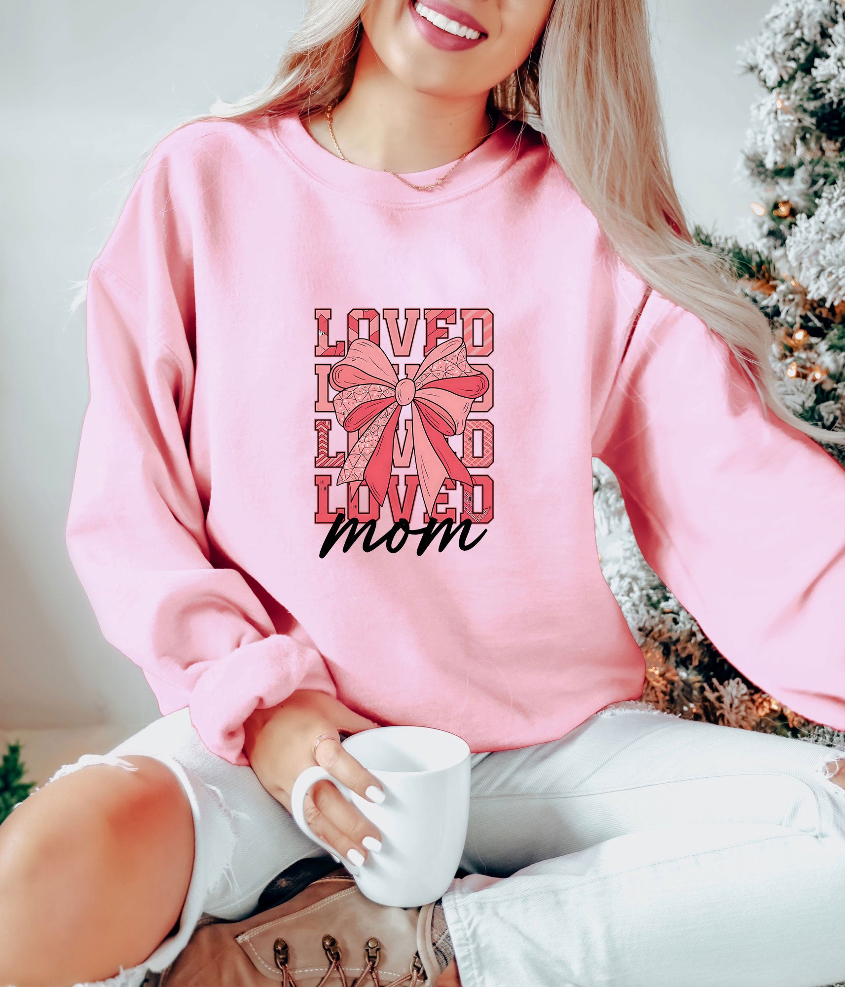 "LOVED Mom" ready-to-press DTF transfer design with pink bow on a pink sweatshirt