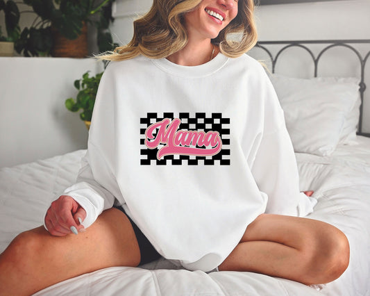 Smiling woman wearing a white sweatshirt with a pink Retro Mama DTF Transfer, featuring a checkered background and vintage-style font.