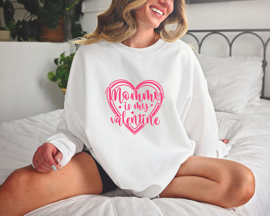 Smiling woman wearing a white sweatshirt with a pink Mommy is My Valentine heart DTF Transfer, perfect for Valentine’s Day.