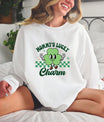 A woman wearing a white sweatshirt featuring a Mommy’s Lucky Charm DTF Transfer with a cute cartoon shamrock and a checkered pattern, perfect for St. Patrick’s Day.