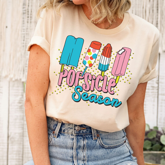 Popsicle Season ready-to-press DTF transfer design on a beige shirt with colorful popsicles and vibrant text.