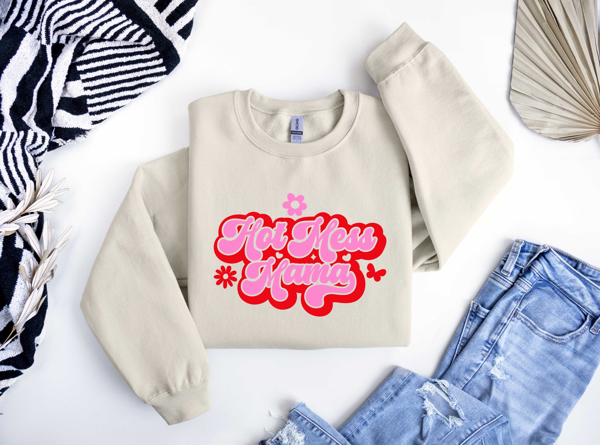 Beige sweatshirt featuring a bold pink "Hot Mess Mama" design with red accents, flowers, and butterflies, perfect for fun Mother's Day fashion.