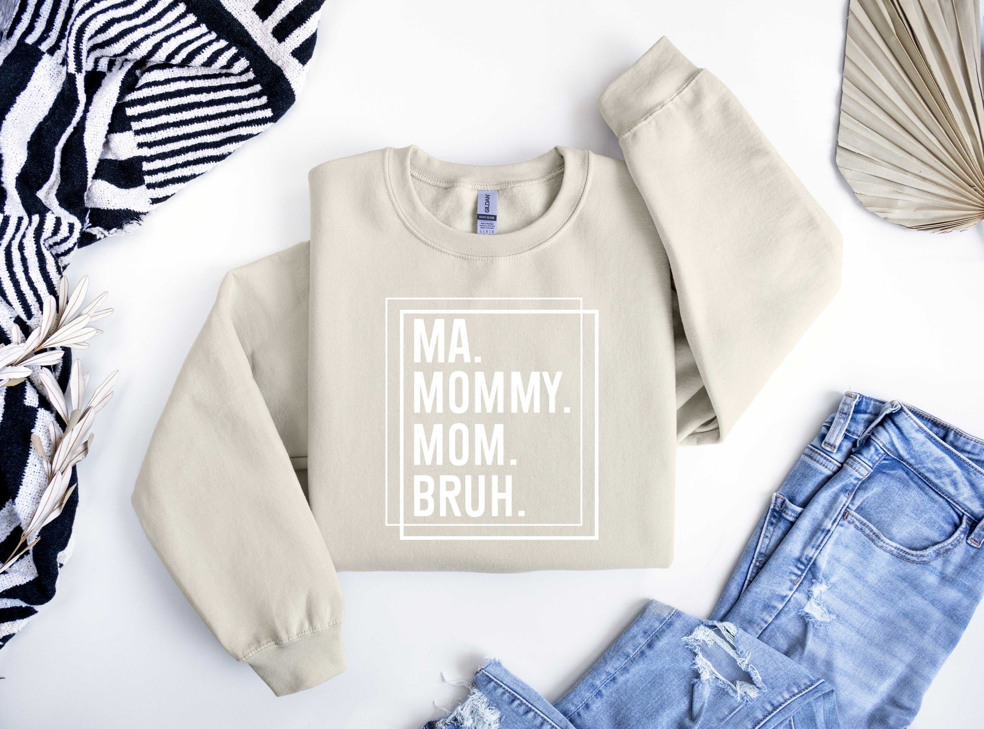 Beige sweatshirt featuring bold white text "MA. MOMMY. MOM. BRUH." inside a double-line square border, perfect for a modern minimalist Mother’s Day look.