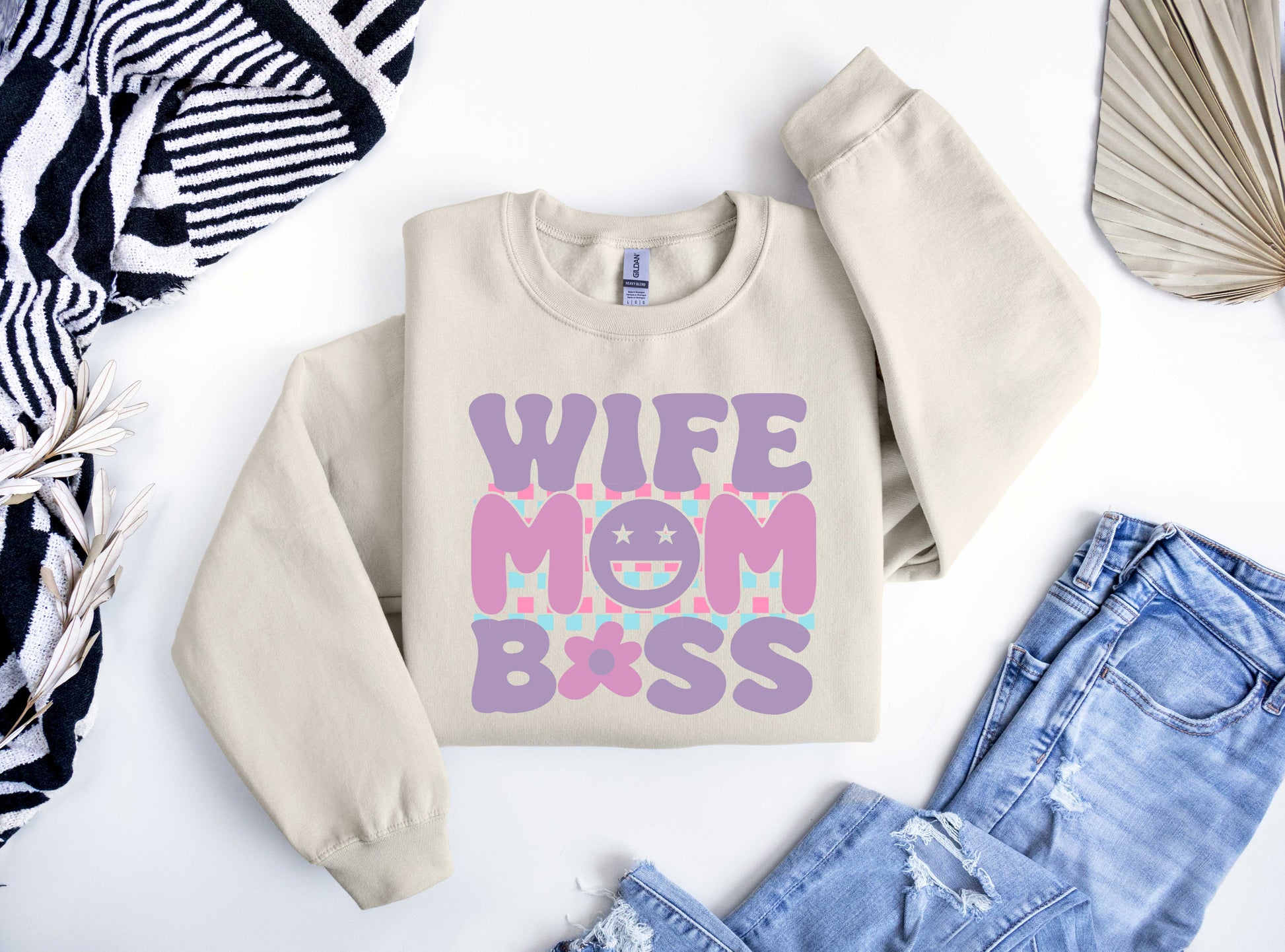 Beige sweatshirt featuring colorful pastel text "Wife Mom Boss" with smiley face and checkered background, perfect for Mother’s Day.