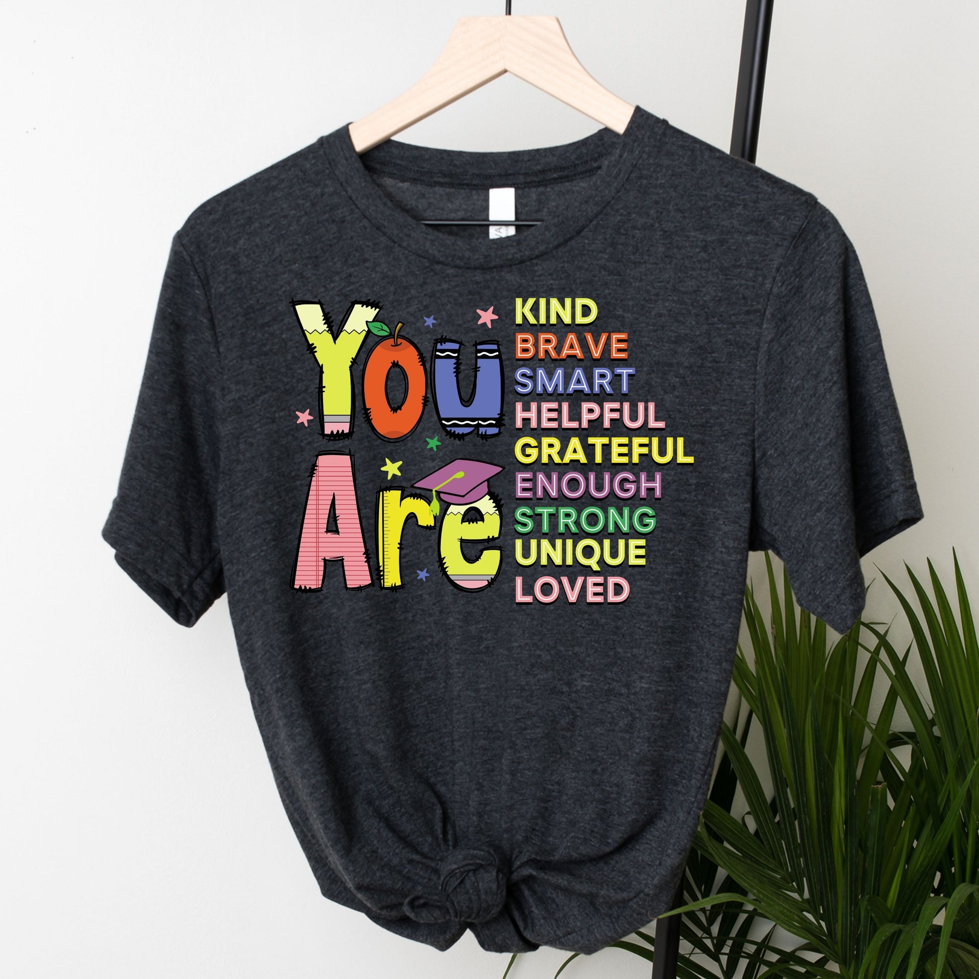 "You Are Kind Brave Loved" DTF transfer design on a dark gray t-shirt featuring vibrant text with an empowering message of self-worth.