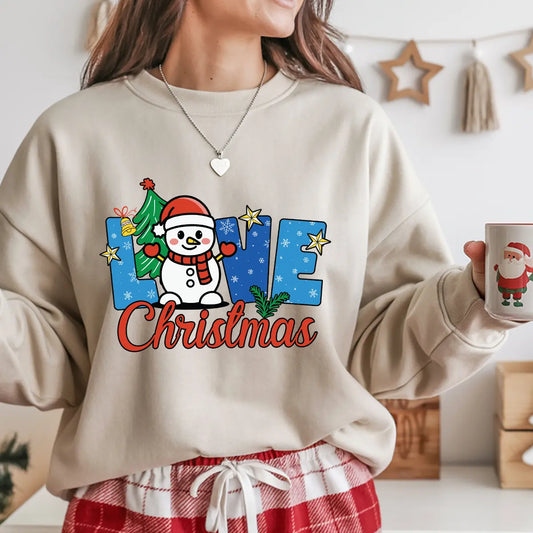 Beige sweatshirt with “Love Christmas” DTF transfer design featuring a snowman in a Santa hat, Christmas tree, stars, and snowflakes—perfect for festive apparel.