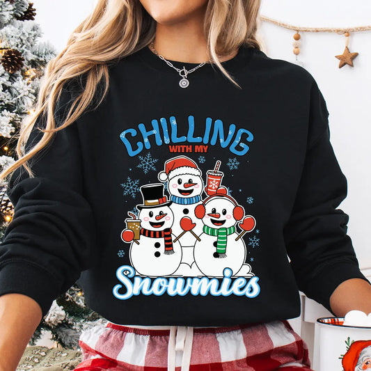 Black sweatshirt with “Chilling with My Snowmies” DTF transfer featuring three smiling snowmen in winter hats and scarves holding drinks, surrounded by snowflakes—perfect for festive apparel.