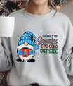 Light gray sweatshirt with “Snuggle Up Gnomies It’s Cold Outside” DTF transfer featuring a cute gnome in a blue hat holding a red mug, surrounded by snowflakes—perfect for cozy winter wear.