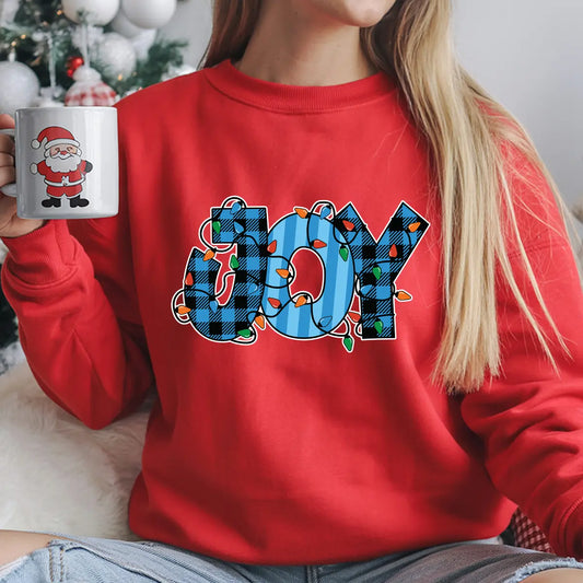 Red sweatshirt with “JOY” DTF transfer featuring blue plaid letters wrapped in colorful Christmas lights—perfect for festive holiday apparel.