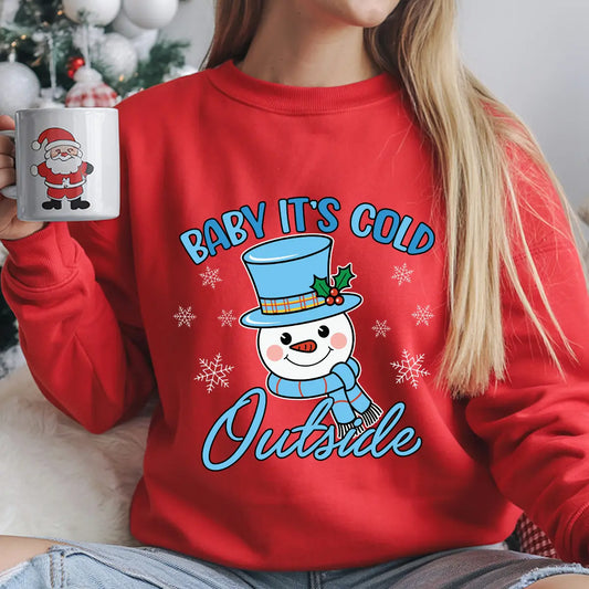 Red sweatshirt with “Baby It’s Cold Outside” DTF transfer featuring a smiling snowman in a blue hat and scarf with snowflakes—perfect for cozy holiday apparel.