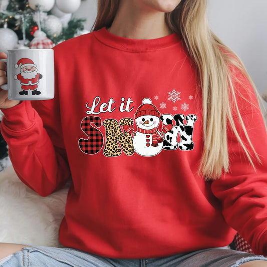 Red sweatshirt with “Let It Snow” DTF transfer featuring a snowman in a red hat, plaid, leopard, and cow print letters—perfect for trendy holiday apparel.