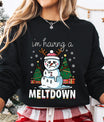 Black sweatshirt with “I’m Having a Meltdown” DTF transfer featuring a melting snowman with reindeer antlers, Christmas trees, and gifts—perfect for funny holiday apparel.