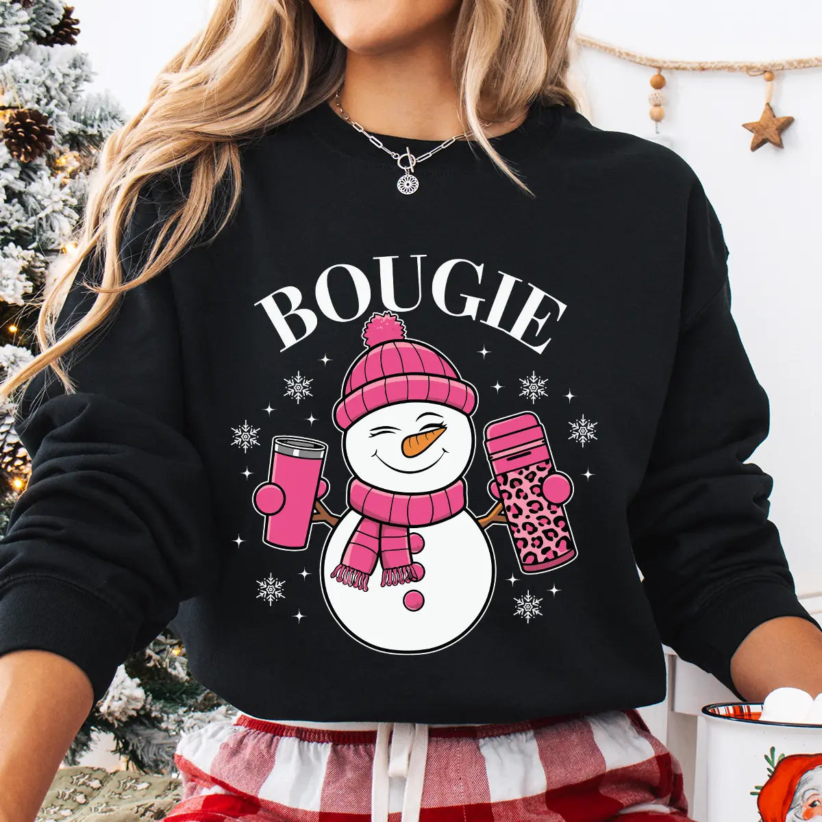 Black sweatshirt with “Bougie” DTF transfer featuring a smiling snowman in a pink hat and scarf holding coffee cups, surrounded by snowflakes—perfect for chic winter apparel.