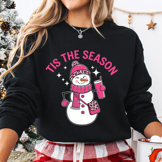 Black sweatshirt with pink “Tis the Season” DTF transfer featuring a fashionable snowman in pink leopard-print hat and scarf holding a drink cup.