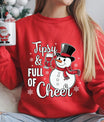 Red sweatshirt with “Tipsy & Full of Cheer” DTF transfer featuring a smiling snowman holding a wine glass and wearing a red scarf and top hat.