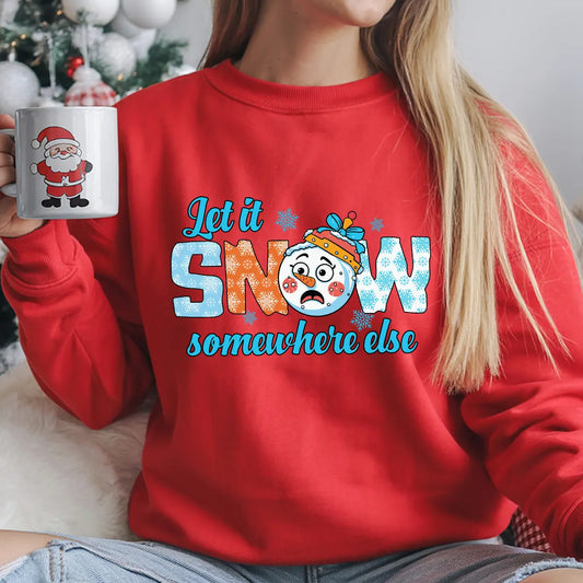 Red sweatshirt with a cartoon snowman and the text “Let It Snow Somewhere Else” in blue and orange winter-themed letters.