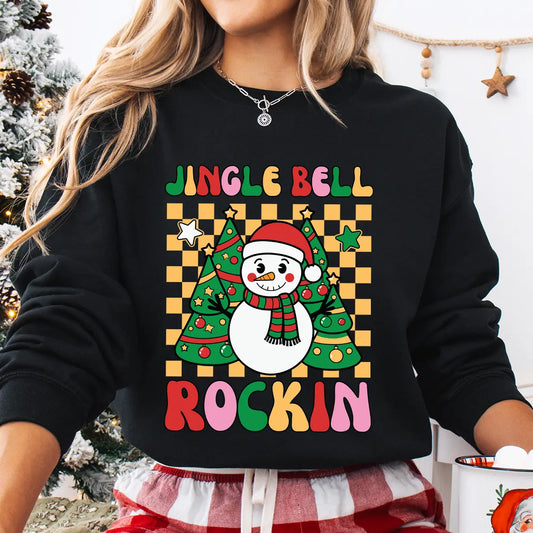 Black sweatshirt with a colorful “Jingle Bell Rockin’” design featuring a smiling snowman and Christmas trees on a yellow checkerboard background.