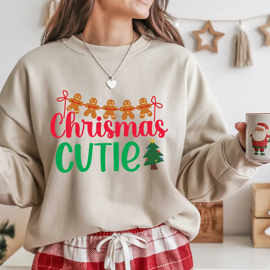 Beige sweatshirt with colorful “Christmas Cutie” text, gingerbread men garland, and small Christmas tree graphic.