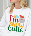 White sweatshirt with “I’m Snow Cutie” text, Santa face, and shooting star graphic — festive Christmas sweatshirt.