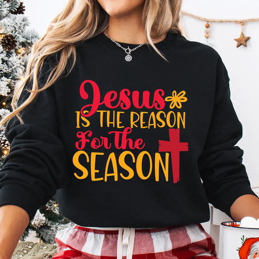 Black sweatshirt with “Jesus Is the Reason for the Season” red and yellow text and cross design – faith-based Christmas sweatshirt.