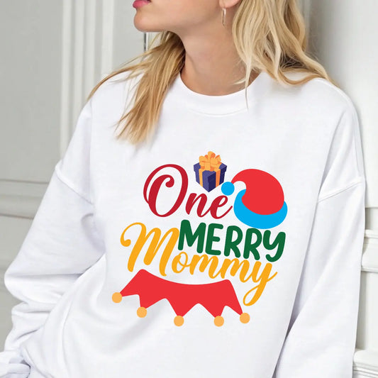 White sweatshirt with “One Merry Mommy” design featuring a Santa hat and gift, perfect festive apparel for moms at Christmas.