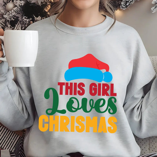 Gray sweatshirt with colorful text “This Girl Loves Christmas” featuring a red Santa hat and festive design elements.