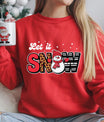 Red sweatshirt with “Let It Snow” design featuring leopard and striped letters with a cute snowman in the middle.